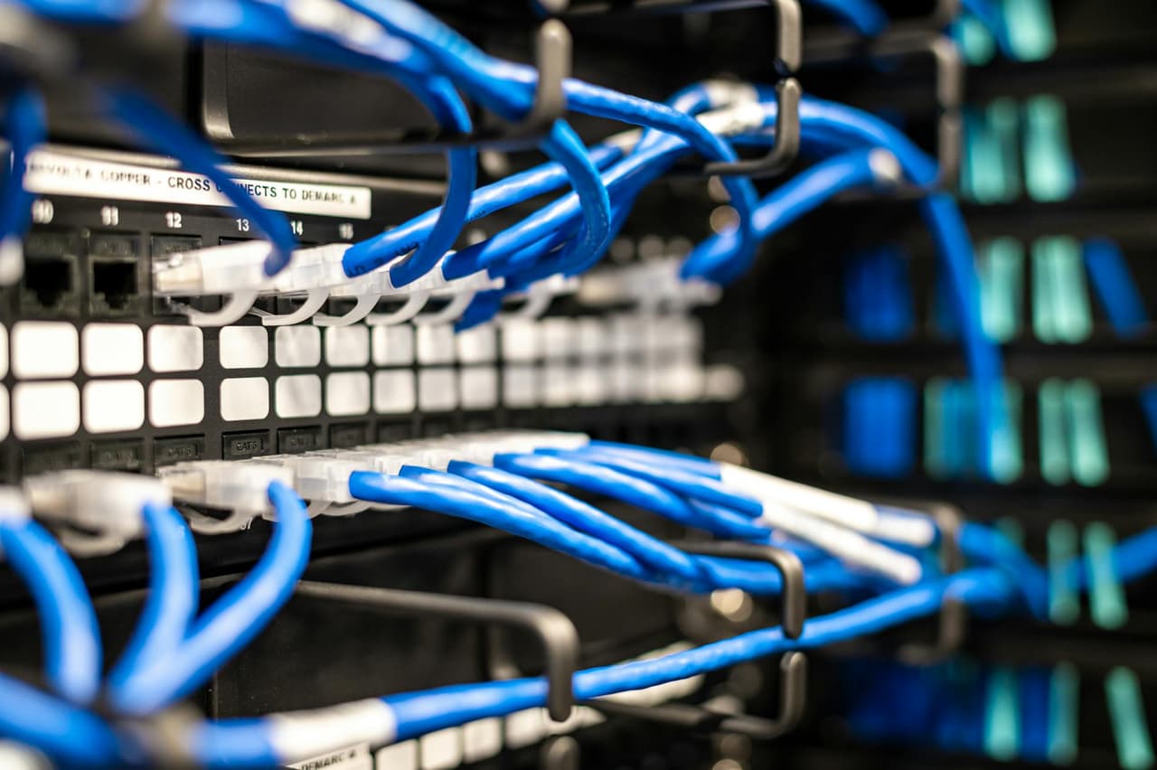 Switch Cisco Catalyst montado en rack de datacenter con puertos SFP activos y cables de fibra óptica organizados, representando la infraestructura típica donde los módulos compatibles de terceros operan sin restricciones en equipos Cisco