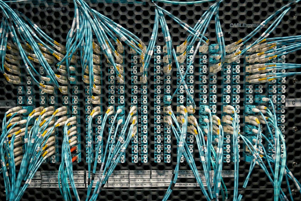 Módulos transceptores SFP y QSFP de distintos factores de forma sobre fondo de fibra óptica iluminada, mostrando la evolución de 1G a 400G