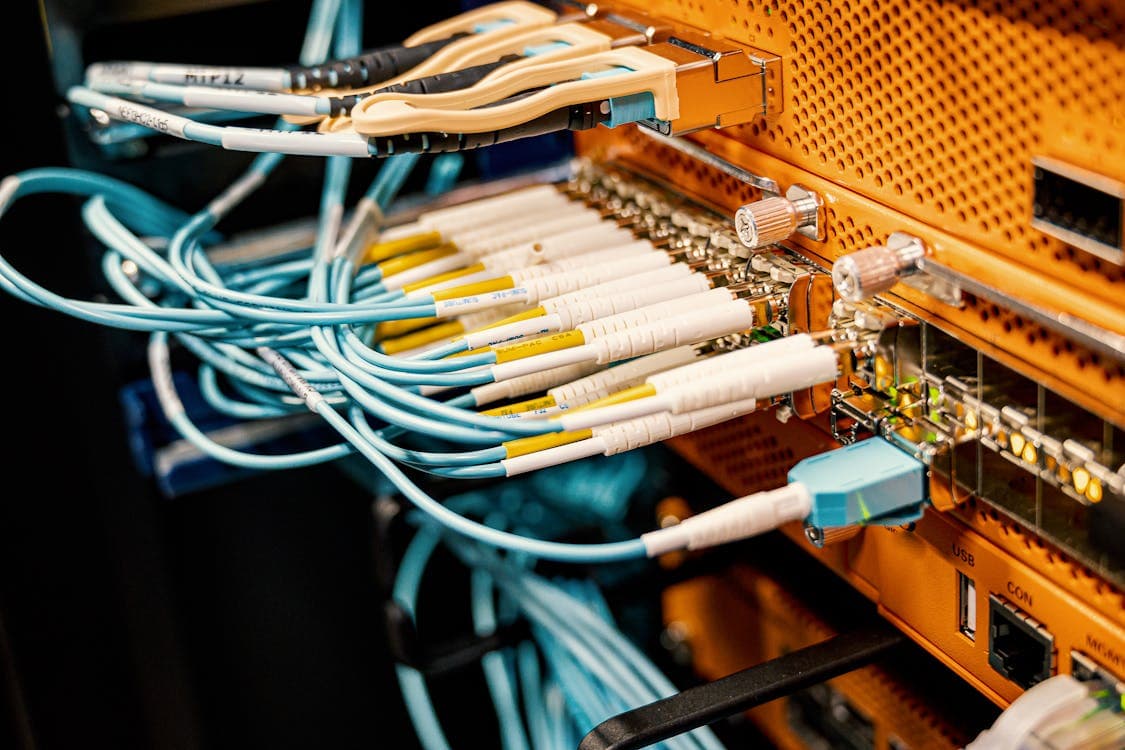 Switch Juniper EX con módulos SFP instalados y cables de fibra óptica en rack de datacenter empresarial