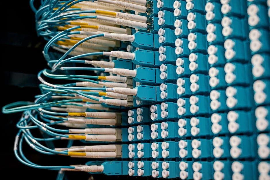 Técnico insertando módulo QSFP28 100G en puerto de switch de datacenter de alta densidad, mostrando el proceso de instalación del factor de forma estándar compatible con cages QSFP+ y QSFP28 para actualizar infraestructura de red de 40G a 100G sin cambiar el chasis