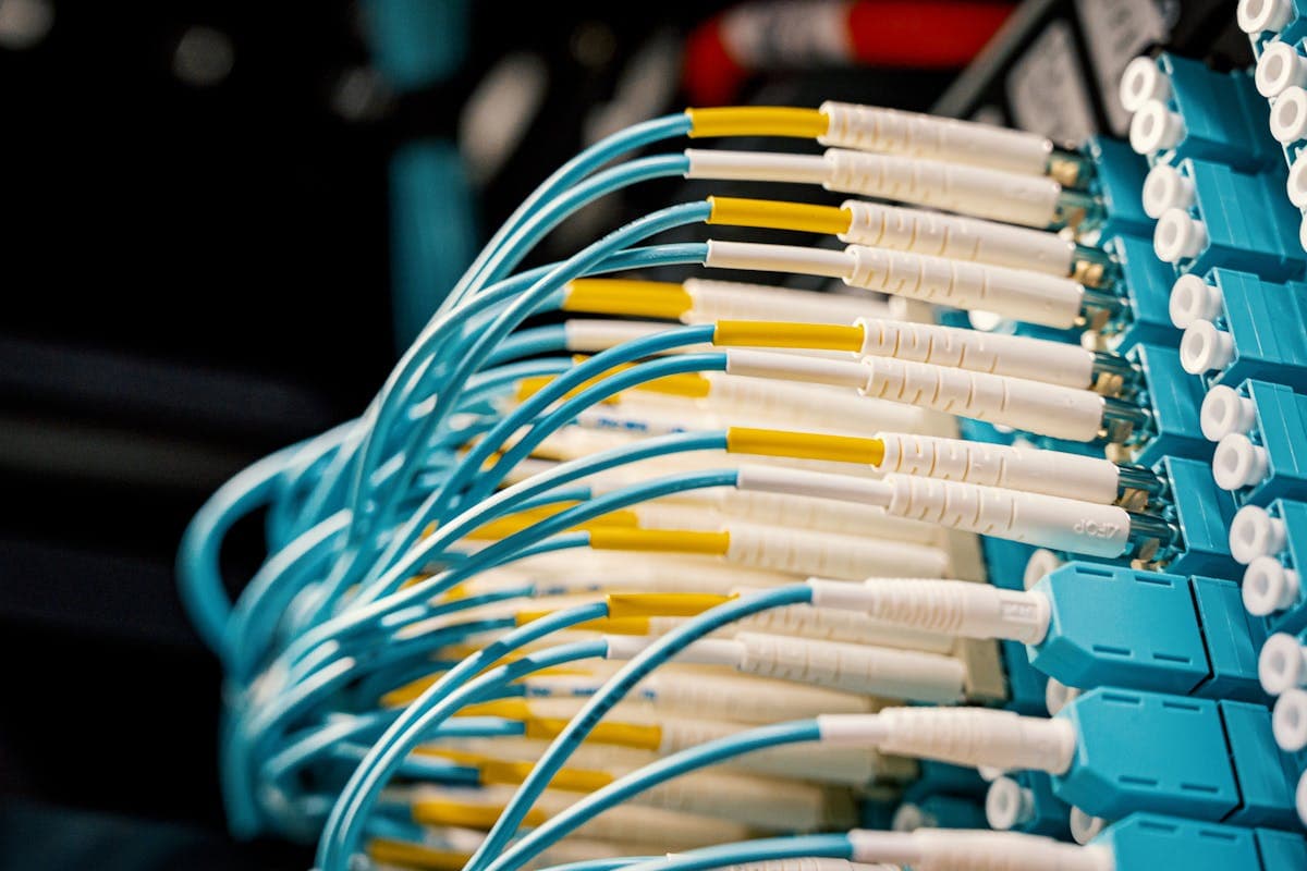 Vista cenital de un switch de fibra óptica con múltiples cables LC conectados en una sala de servidores, ilustrando la alta densidad de conexiones posible con transceptores SFP en equipos de red empresarial
